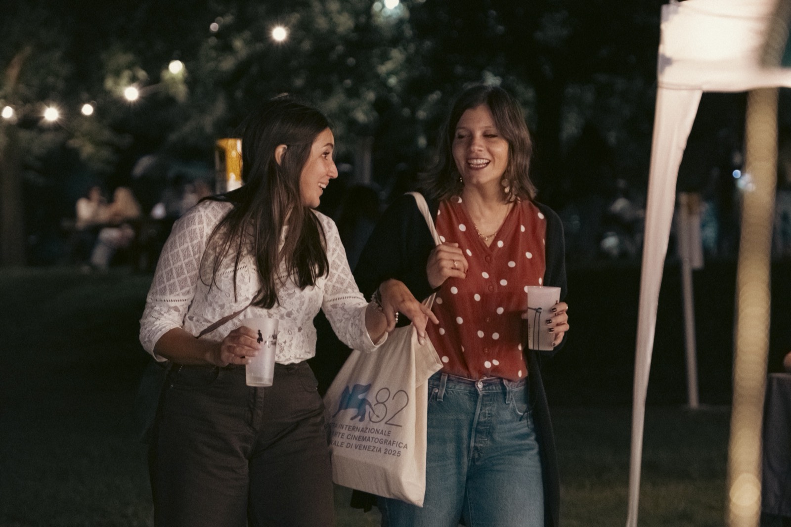 Persone che ridono di sera tra le luci